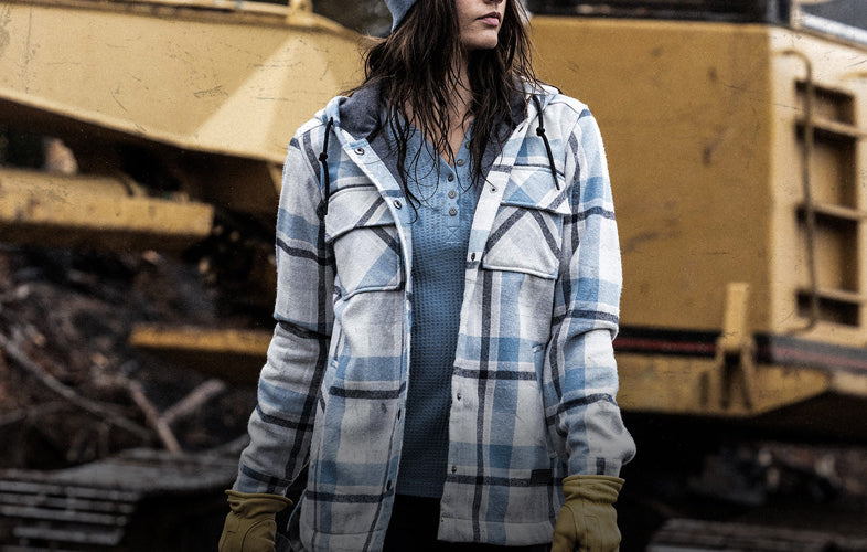 woman wearing jacket standing in front of big construction vehicle